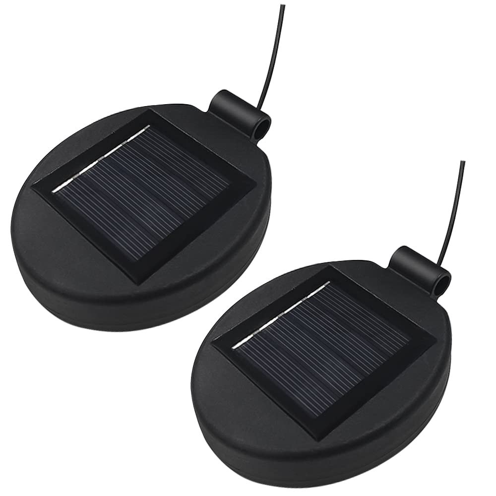 Two black solar panel lights with wires attached