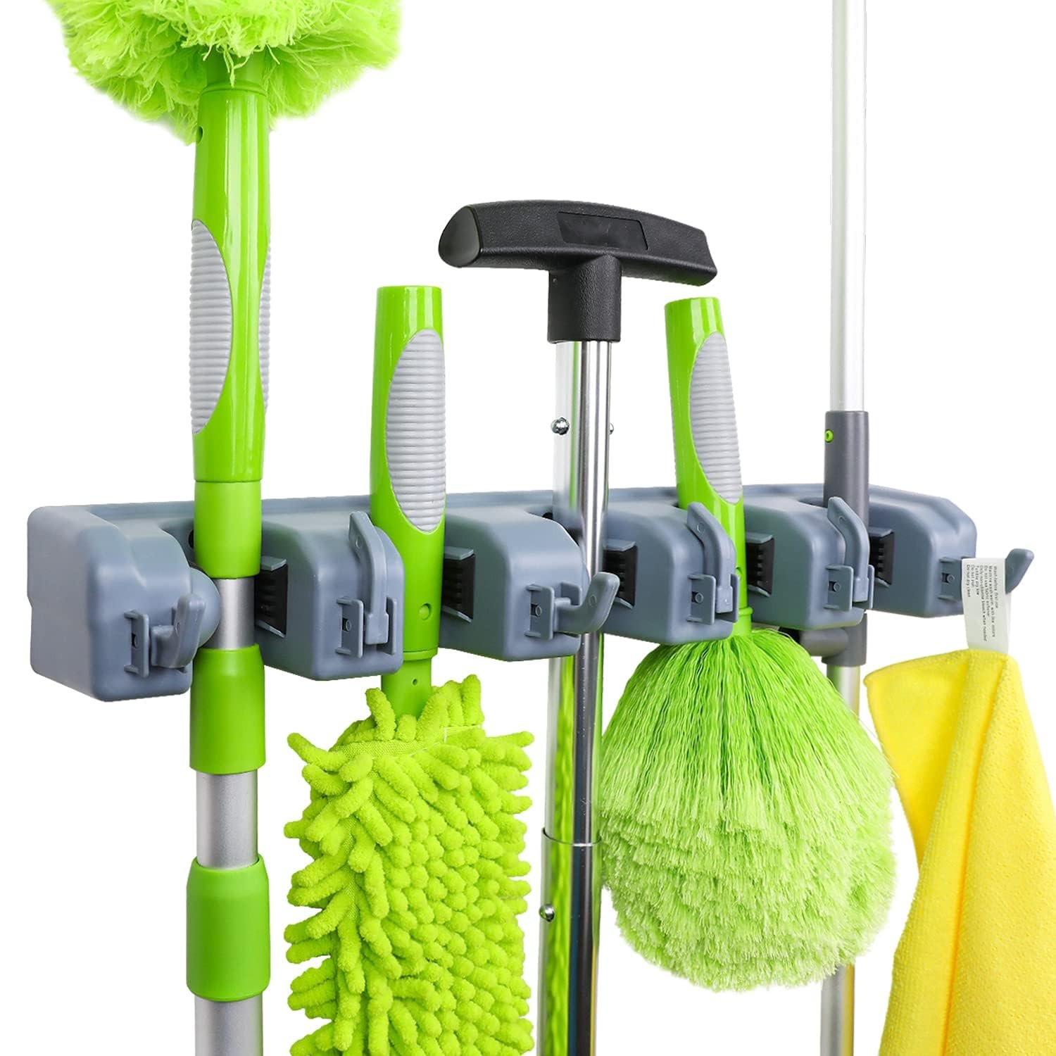 Cleaning tools hanging on a wall-mounted organizer, including mops and dusters